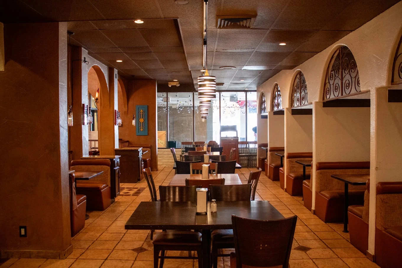 The dining room looking down the aisle, booths on both sides and arched alcoves along the right wall.